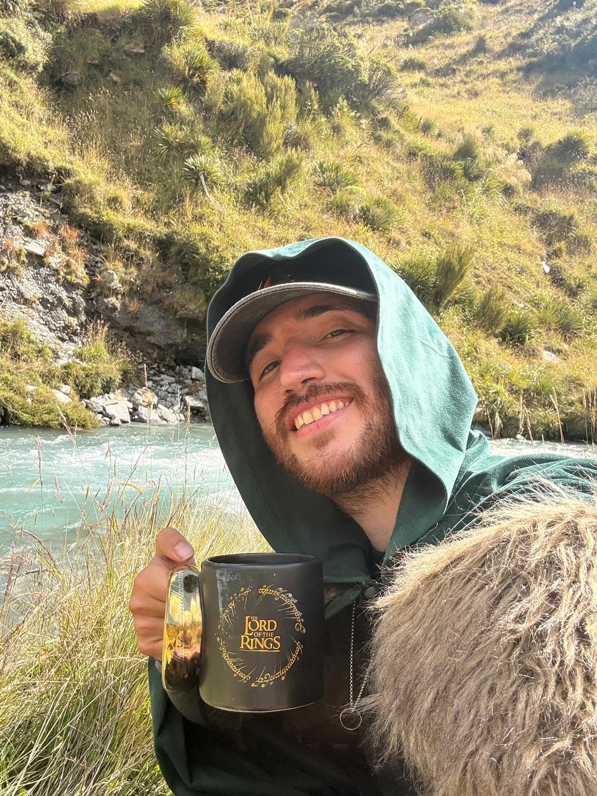 Morning coffee with LOTR mug by a river